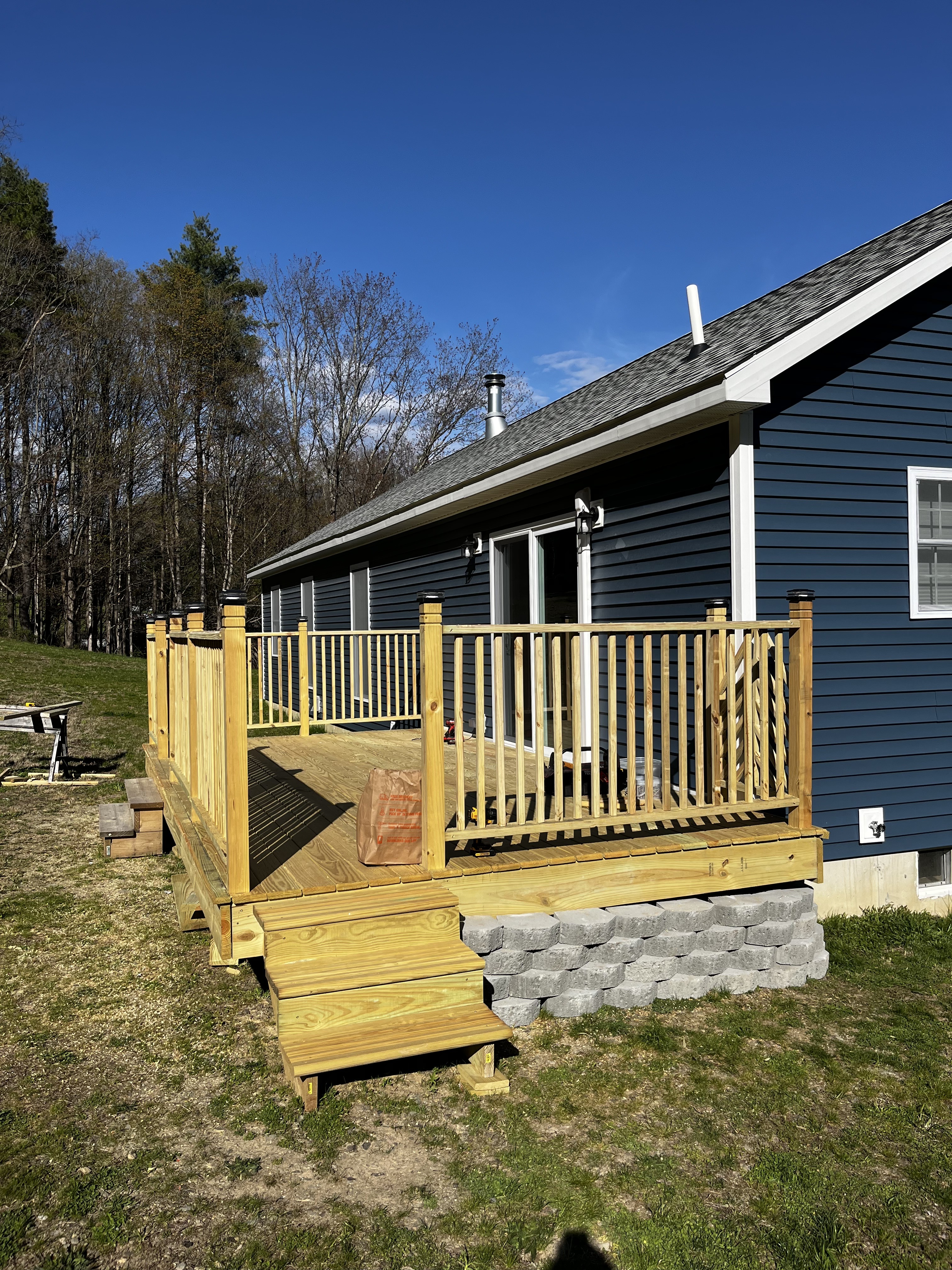 Angled view of the deck stairs, railings, and stone step base.